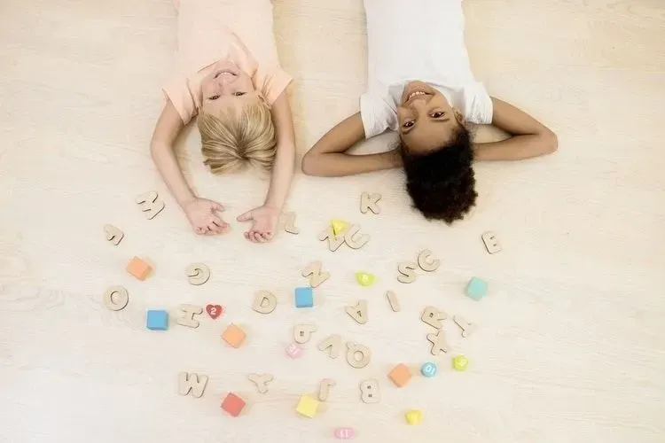 Two kids playing with wooden alphabets