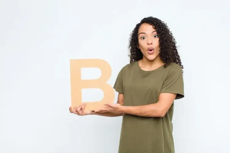 A woman holding the letter B