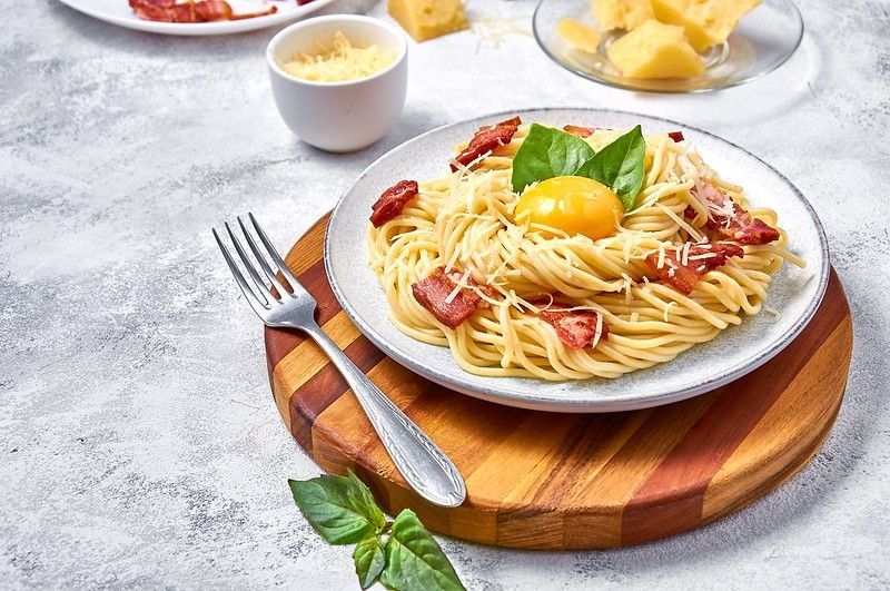 Traditional Italian Pasta Carbonara with bacon, cheese and egg yolk on plate