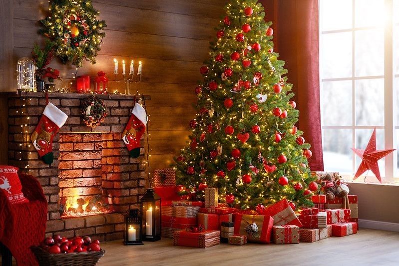 Christmas tree decorated with gifts in house interior.