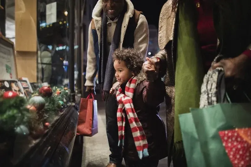 parents with their little boy looking at a window shop during Christmas