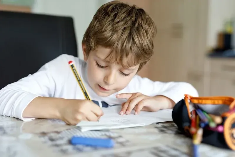 young boy drawing and writing