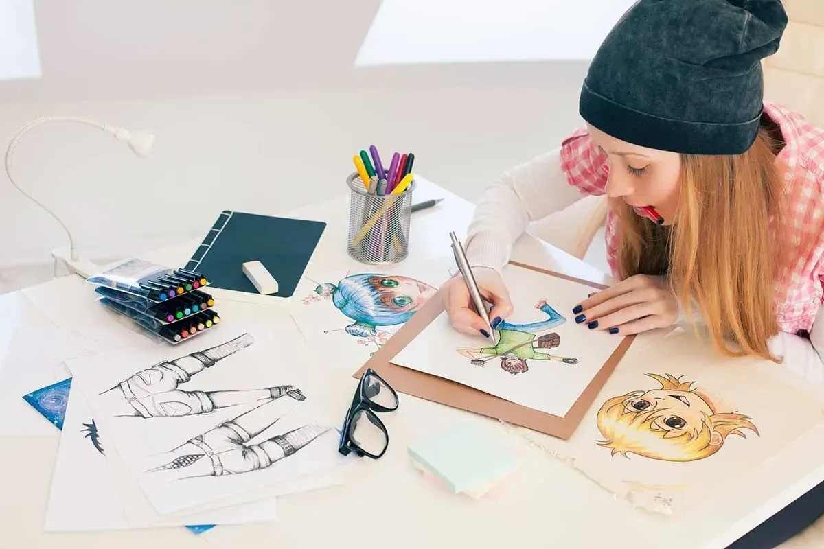 A teen girl drawing and writing at her desk.
