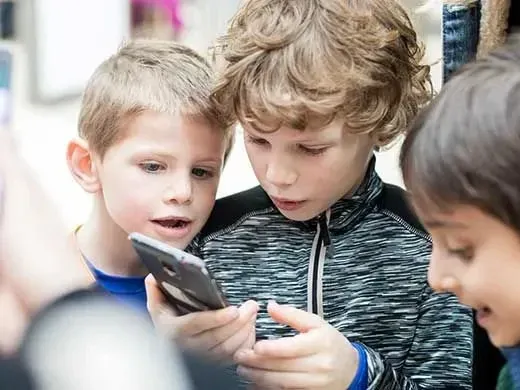 Kids looking at a phone for the text quest.