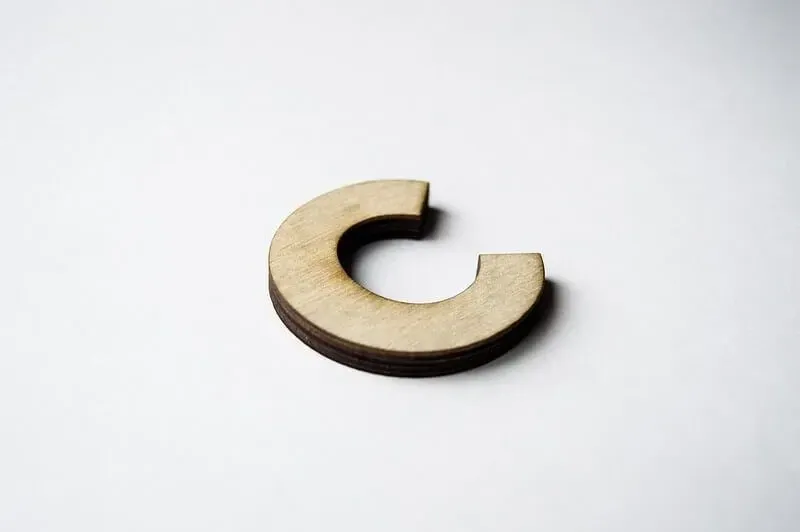 A wooden letter C on a white background