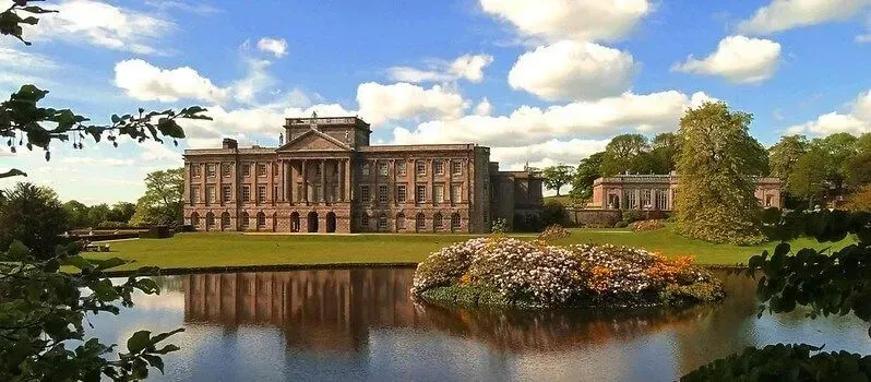 National Trust Lyme House behind a large lake 