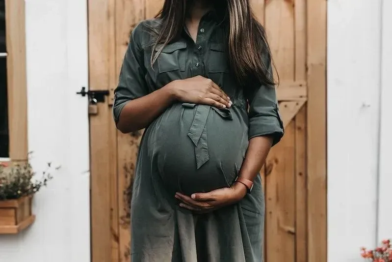 Pregnant woman cradling her belly before labour.
