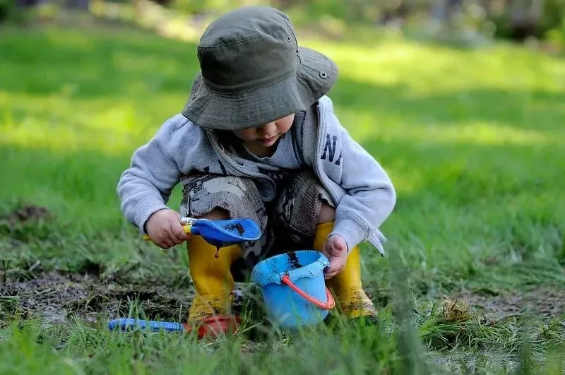 Young boy plays in the mud, enjoying the fantastic minibeasts activities