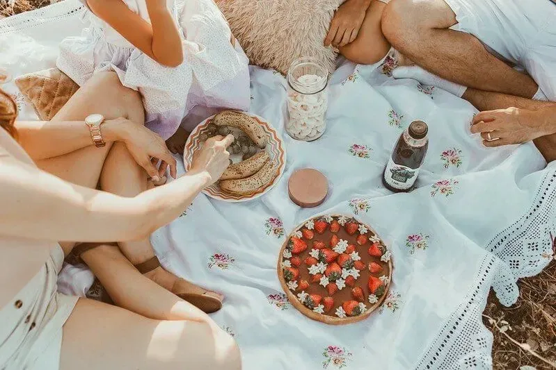 overhead shot of a family eating fruit at a picnic