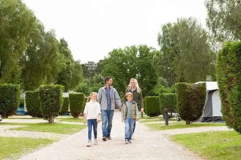 Family smiling and excited as they arrive at Sandford Holiday Park, Dorset.