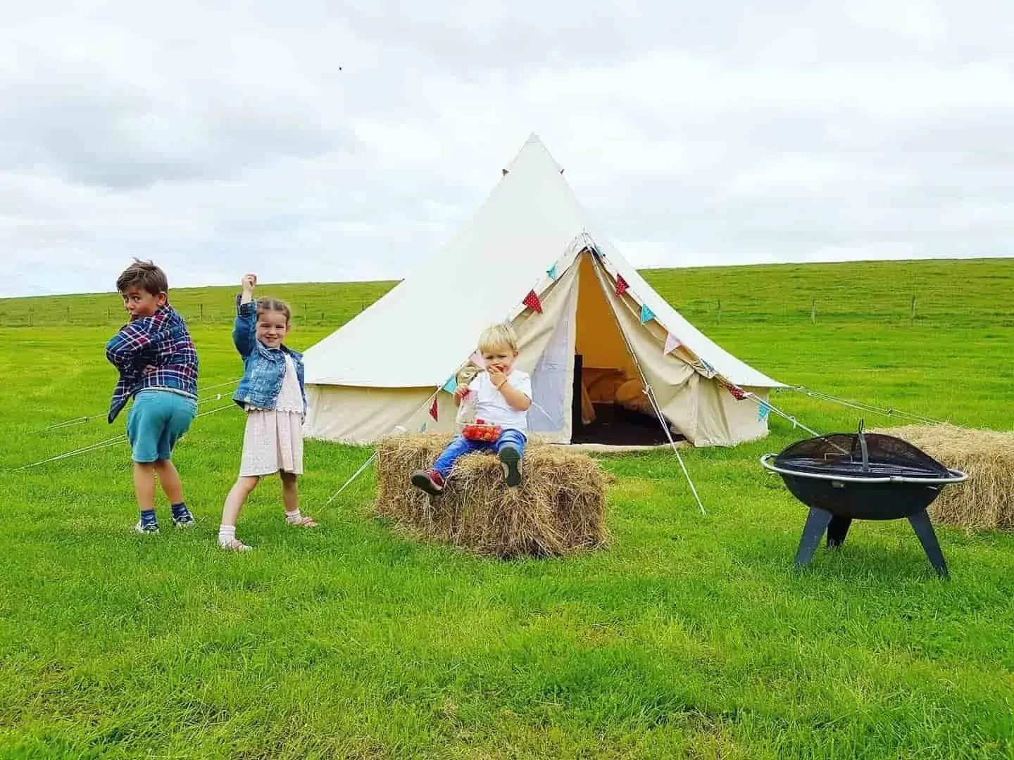 Kids enjoying their teepee during staycation at Dewflock Farm campsite, Dorset.