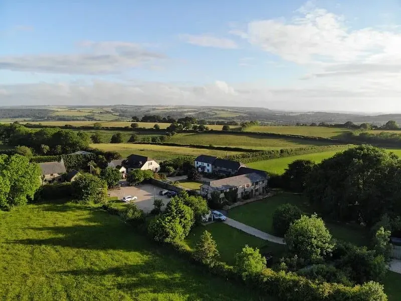 Aerial view of Lancombe Country Cottages, Dorset, surrounded by rolling fields.