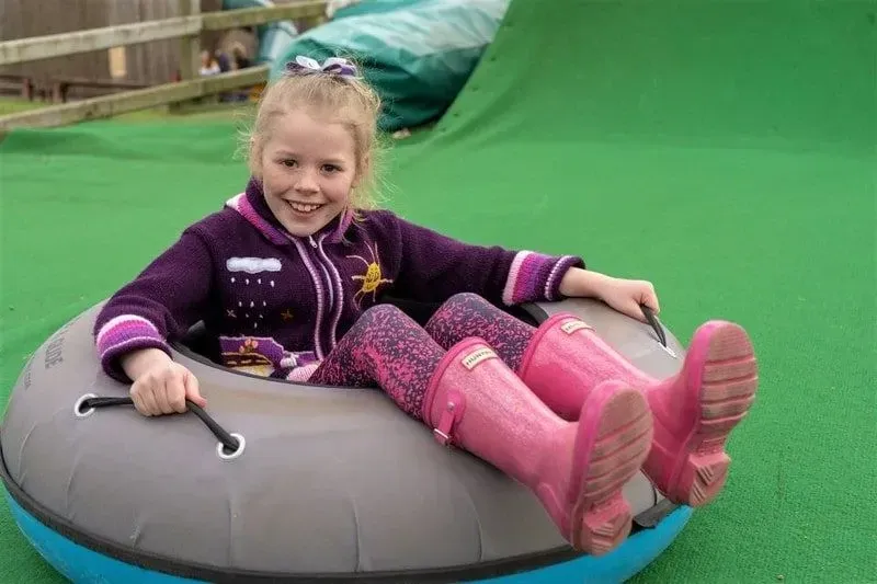 Girl sitting in a doughnut on the slide at Adventure Valley