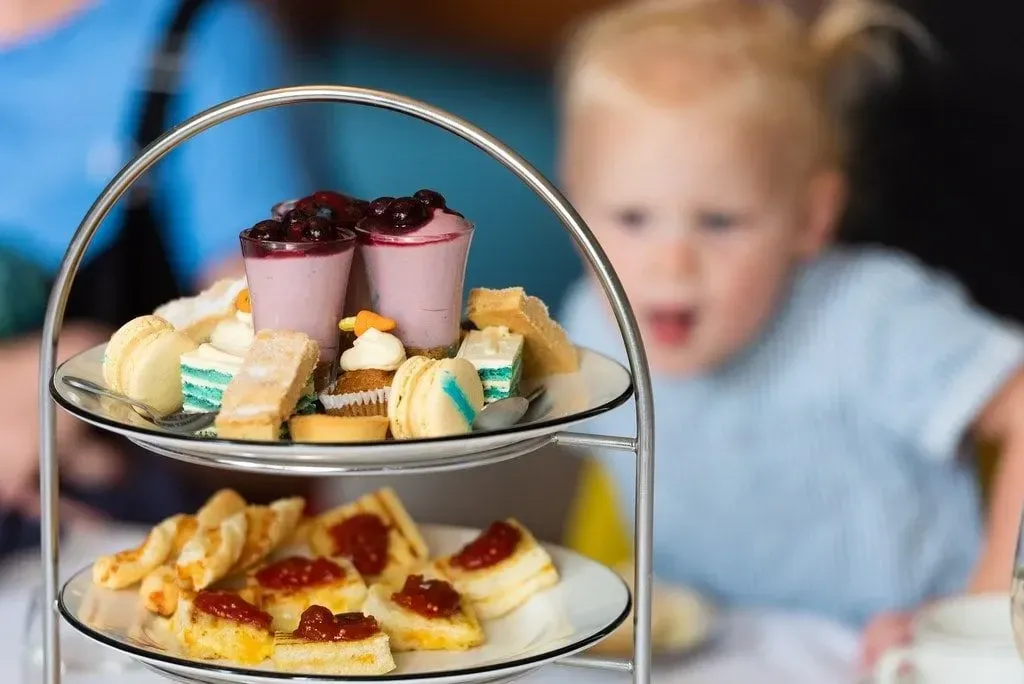 Child looking at the food at a family-friendly afternoon tea in Norwich.