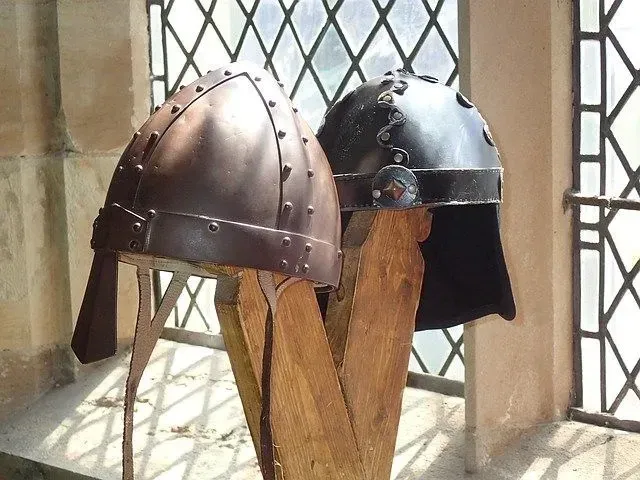 Two Viking helmets on a stand by the window.