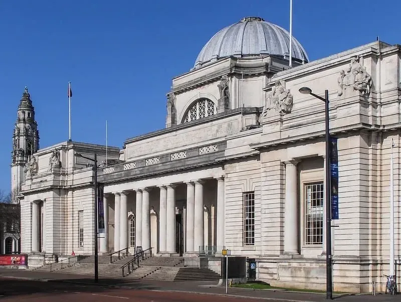 The grand front entrance to the Cardiff National Museum with statues and columns.