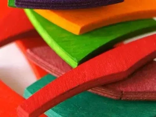 A pile of colourful wooden pieces cut out in different shapes.