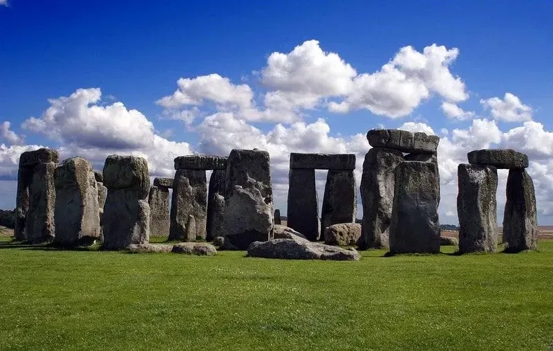 Stonehenge on a sunny day with a blue sky and clouds.