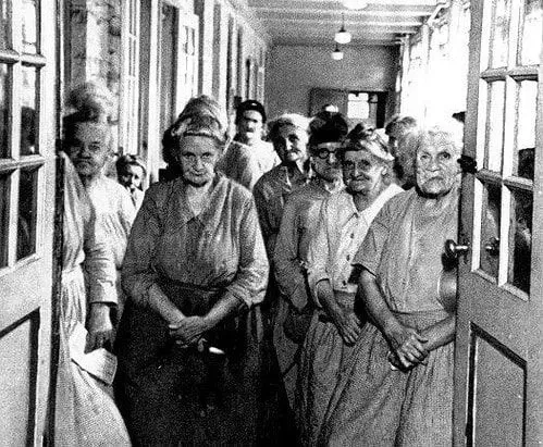 Women standing in the hallway of the Victorian workhouse.