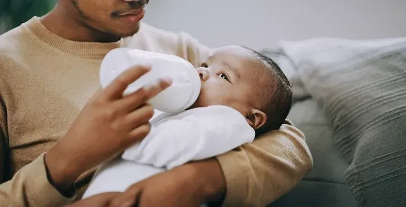 Dad feeding baby with bottle