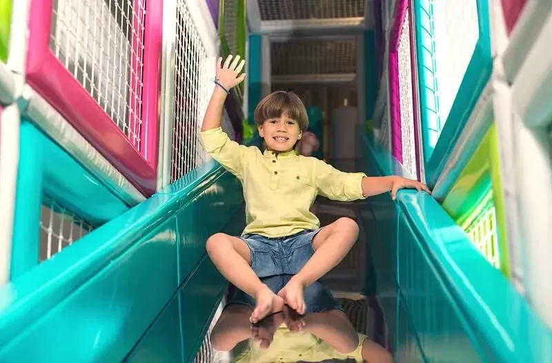 child on slide in indoor playground