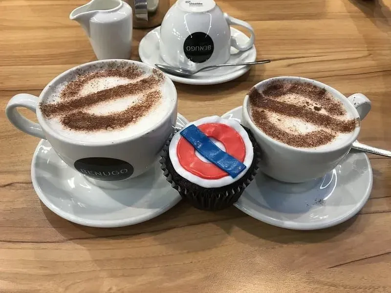 Underground roundel-themed refreshments: a cupcake and two mugs of coffee. 