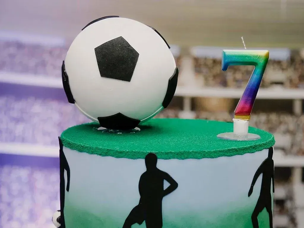 A birthday cake with a large fondant football on top, perfect for sport loving tweens and teens.