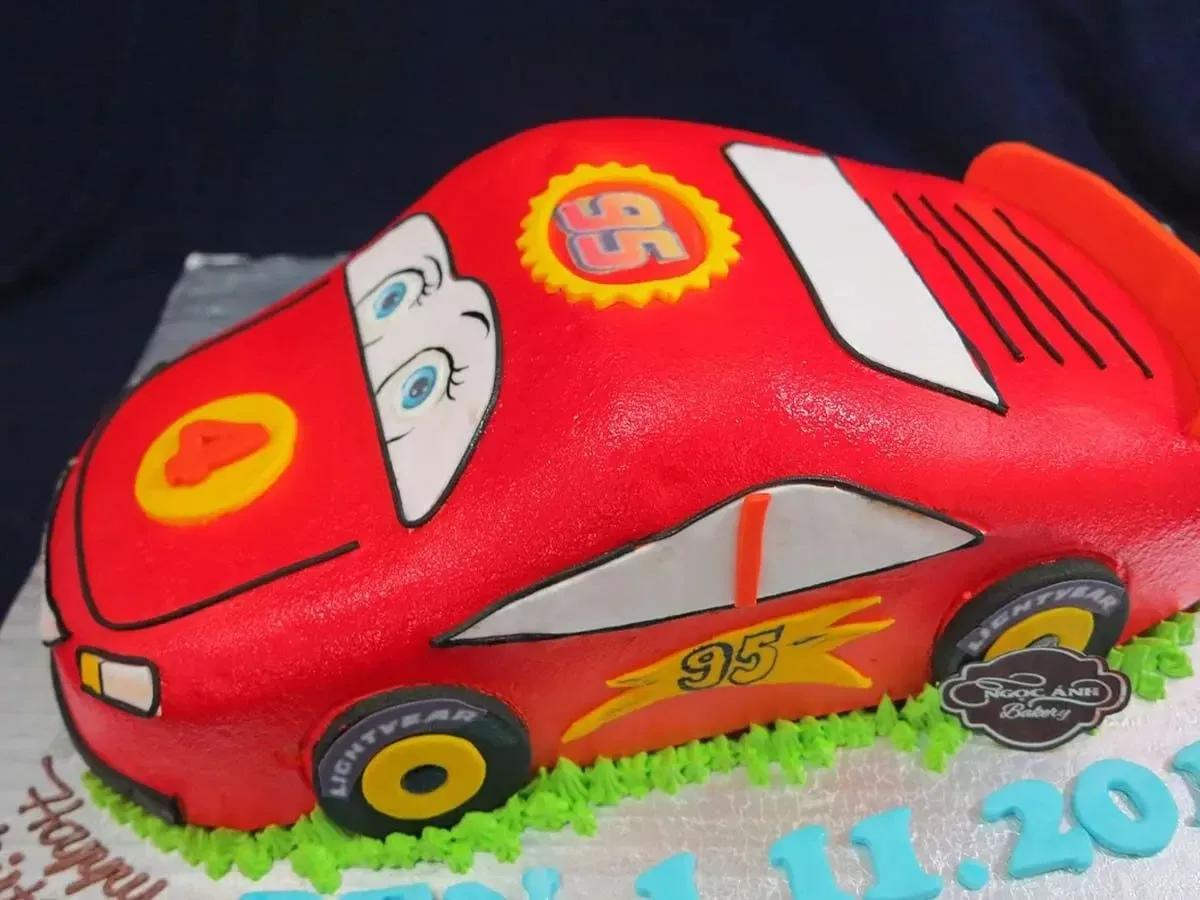 Red car cake that looks like Disney's 'Cars' character Lightning McQueen.
