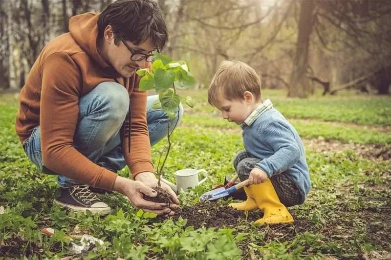 A father and son at an outdoor garden. Image