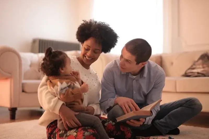 Parents reading a book for their little girl