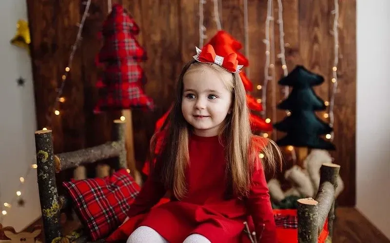 Girl in red Christmas dress on Christmas day.