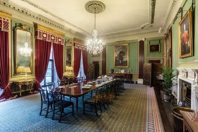 A large rectangular dining table standing in the centre of one of the State Rooms at Hillsborough Castle.