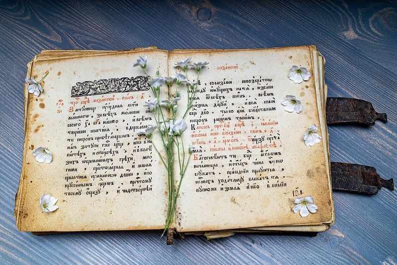 An old prayer book written in Old Church Slavonic language with white flowers