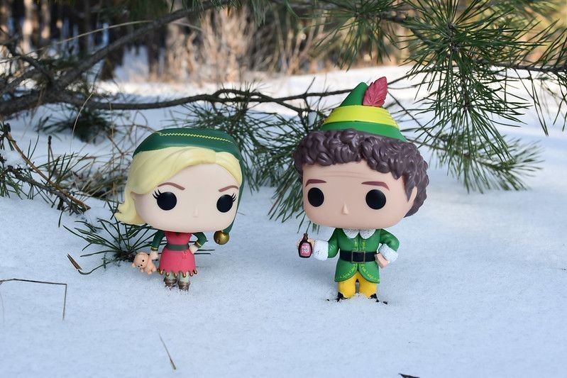 Toy figurines of elf and his friend on snow.