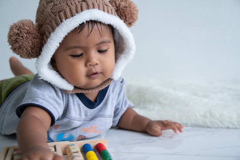 Cute little boy playing with wooden toy
