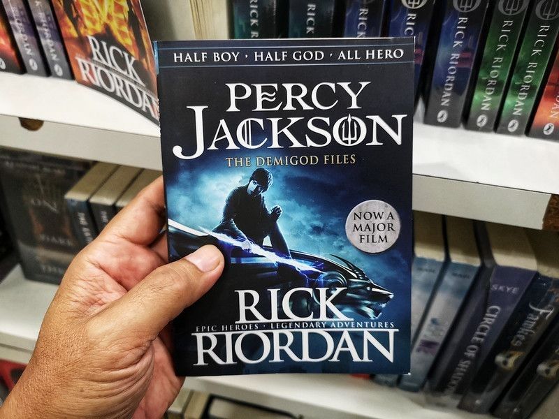 Person holding a book of Percy Jackson