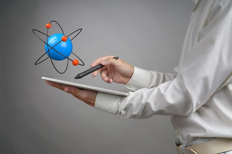Man scientist holding a tablet PC with atom model, research concept