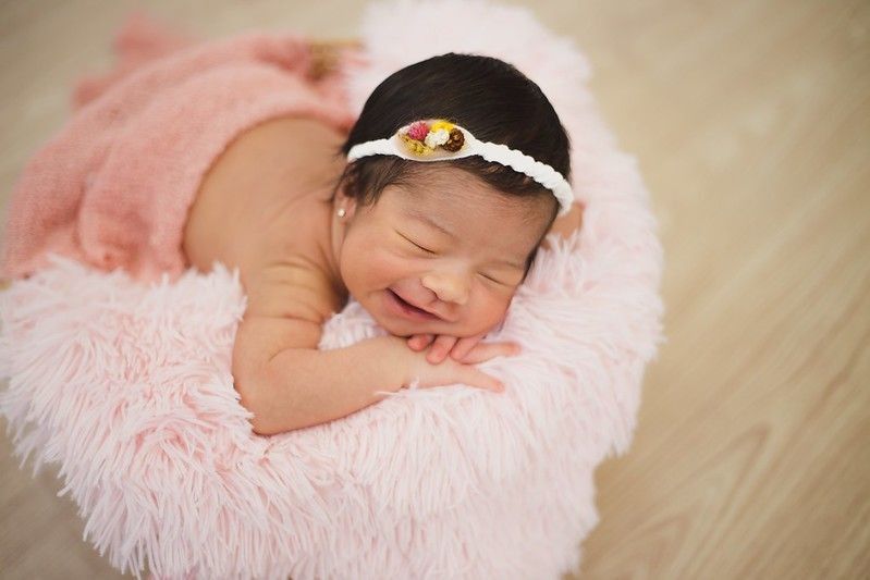 Happy baby girl sleeping on a pink fur)