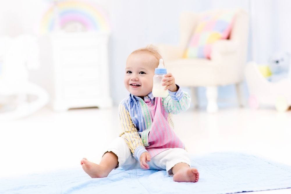 Adorable baby boy playing on a blue floor mat