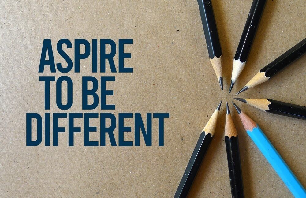 Aspire to be different quote written on a paper