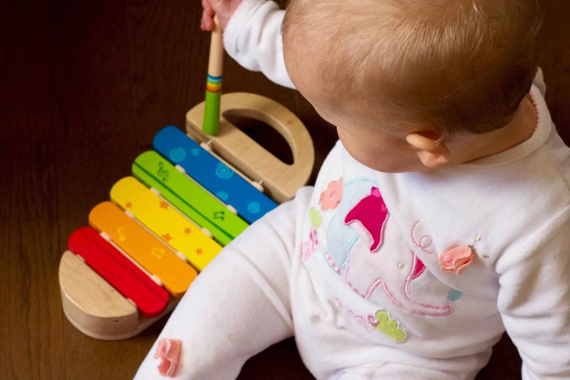 A baby boy playing with xylophone