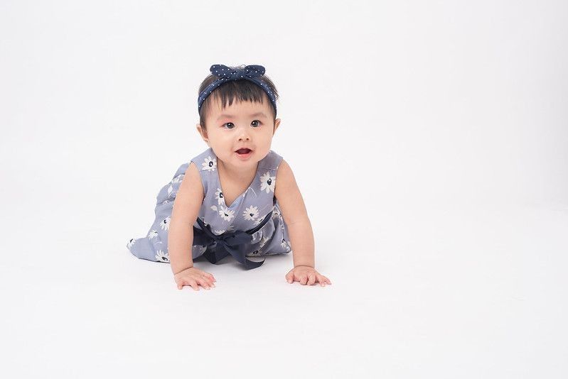 Cute baby wearing blue dress crawling 