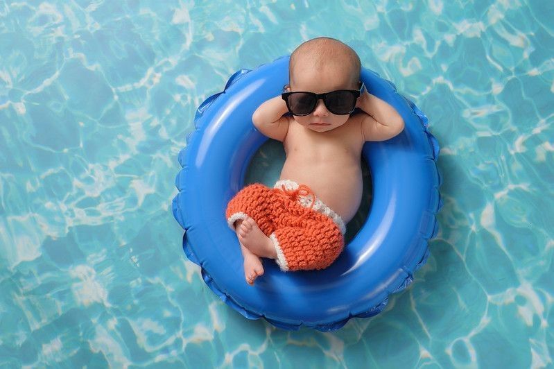 New born baby boy sleeping on a tiny inflatable swim ring