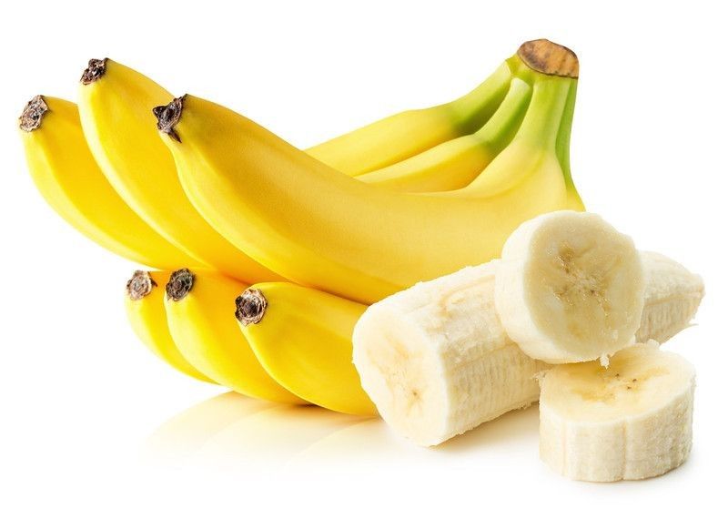 Bright yellow bananas with sliced banana pieces on white background