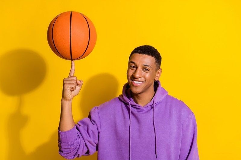 A young man spinning Basketball