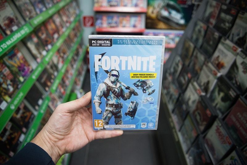 Man holding videogame CD of Fortnite  in store