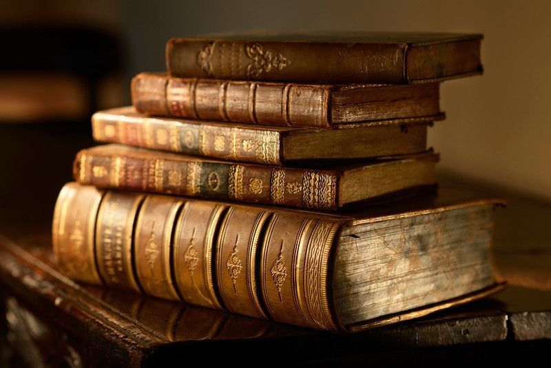 Vintage books pile on wooden surface