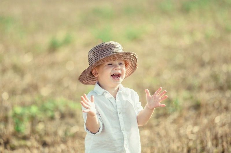 Little boy having good time in a dry grass field