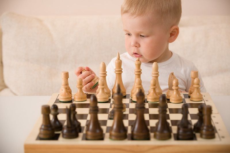 Cute little baby boy playing chess