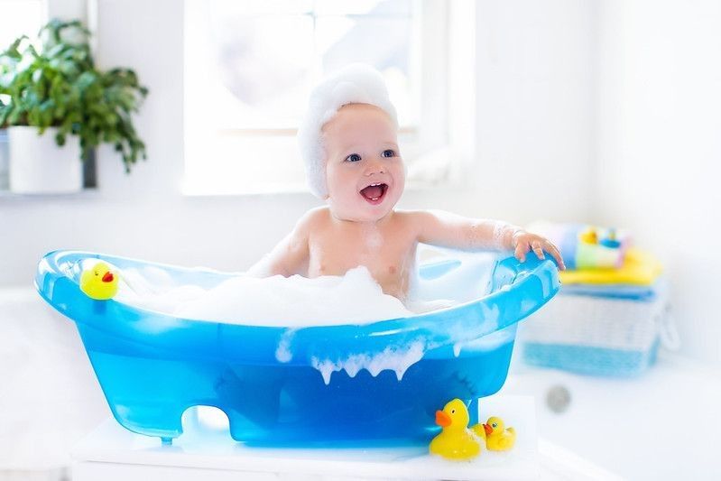 Happy laughing baby taking a bath playing with foam bubbles - Nicknames